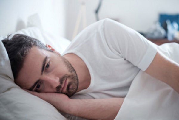 Мужчина лежит в постели. У него полная апатия и депрессия