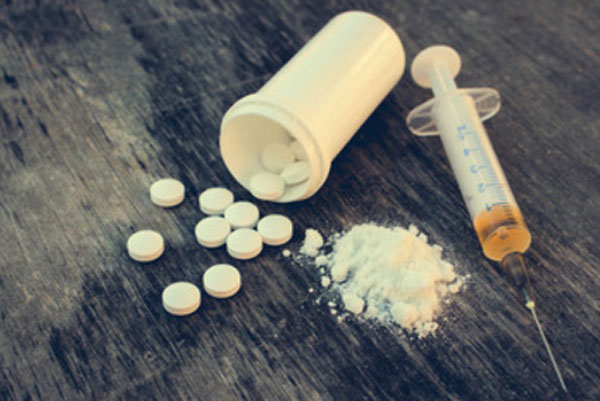 Шприц с жидкостью, флакон с таблетками и рассыпанный порошок