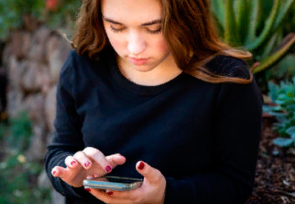 Девочка смотрит на экран своего телефона