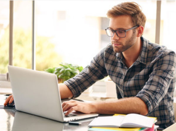 Серьезный мужчина сидит за ноутбуком