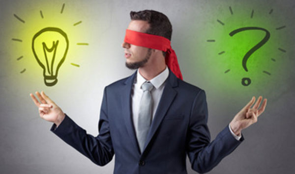 Мужчина с завязанными глазами. С одной стороны от него нарисована лампочка, с другой - знак вопроса
