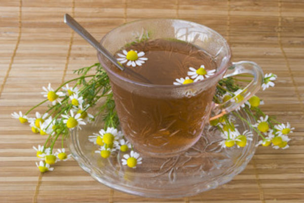 Чашка чая. Рядом лежат ромашки