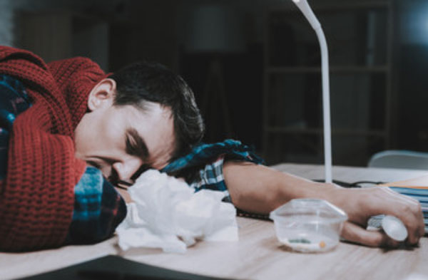 Мужчина положил голову на стол. В руке у него шприц