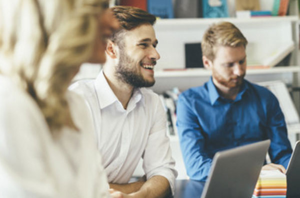 Счастливый мужчина в офисе среди коллег