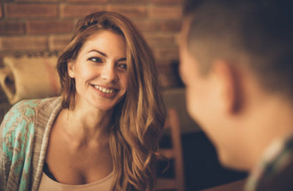 Девушка общается с мужчиной. Она улыбается