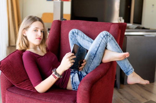 Девочка - подросток лежит на кресле