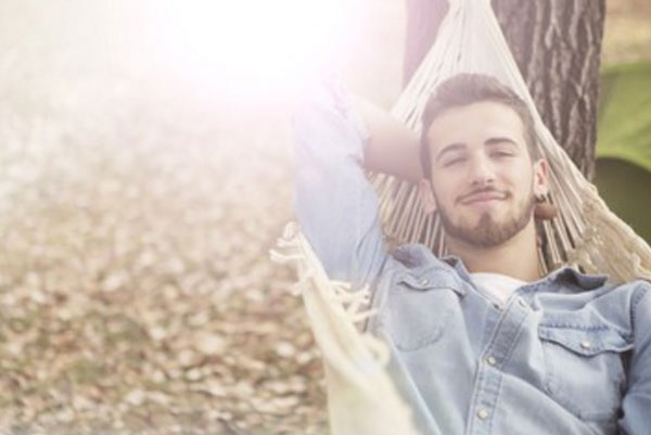 Парень на гамаке, улыбается