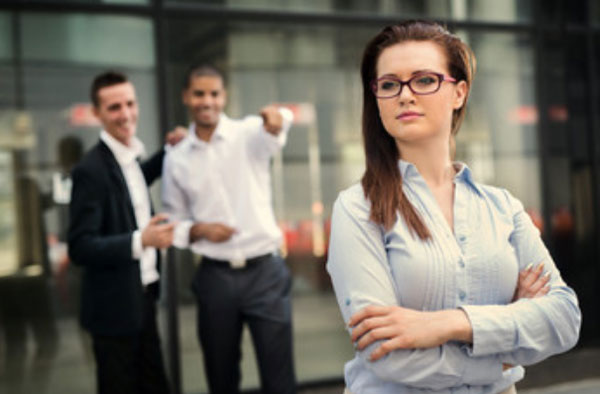 На переднем плане стоит девушка. На заднем - два парня, которые тычат в нее пальцем