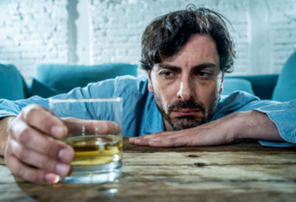 Мужчина держит в руке стакан со спиртным. Томно на него смотрит