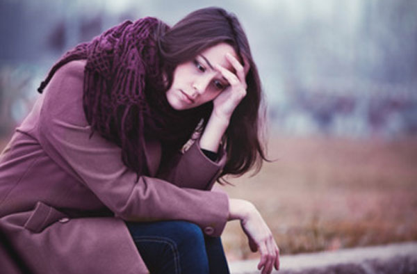 Одинокая девушка сидит на улице