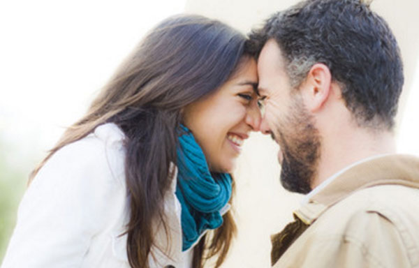 Девушка смеется и прижимается лбом к парню