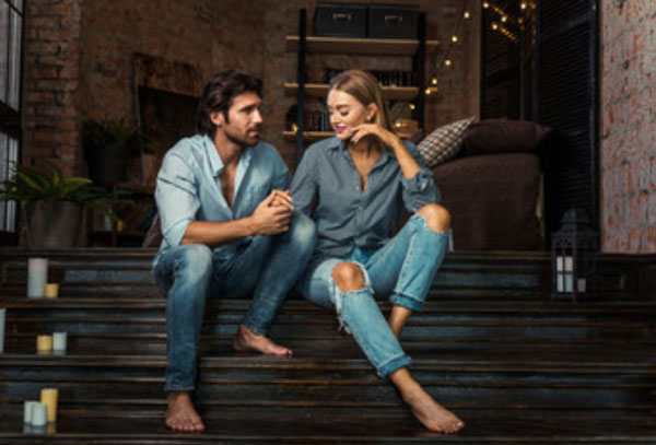 Парень с девушкой сидят на ступеньках. Он что-то говорит