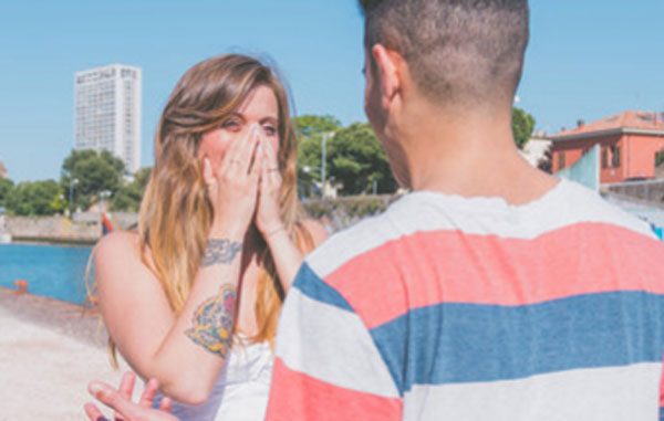 Парень что-то говорит девушке, она смущается