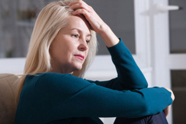 Женщина сидит. У нее потерянный вид