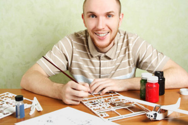 Мужчина собирает модель самолета