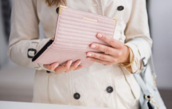 Женщина стоит с открытым кошельком