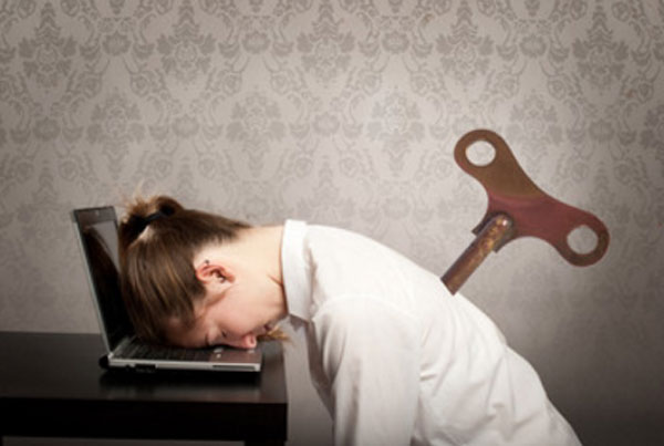 Женщина с ключом в спине положила голову на ноутбук