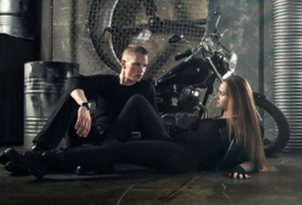 Парень с девушкой на полу в гараже. Он строго на нее смотрит