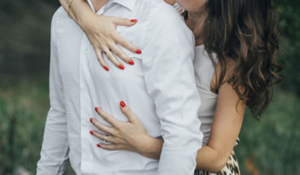 Женщина сзади обнимает мужа