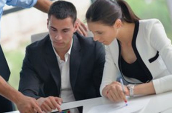 Грустный мужчина смотрит в планшет, рядом другие сотрудники