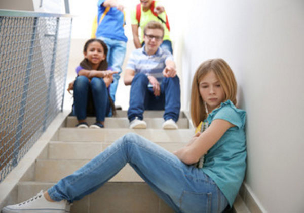 Девочка сидит поперек ступенек. Выше нее находятся ребята