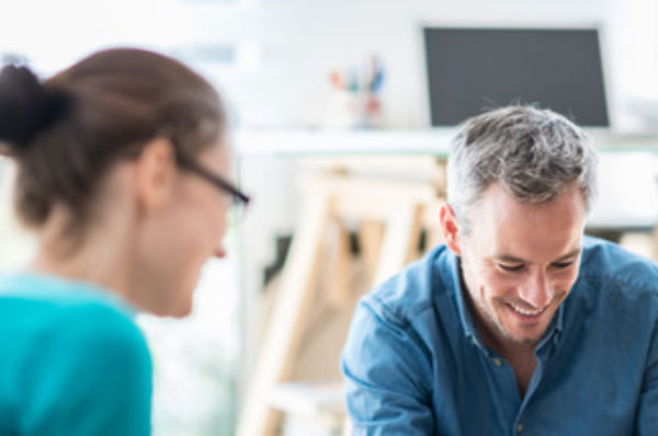 Мужчина сидит в полуобороте от женщины