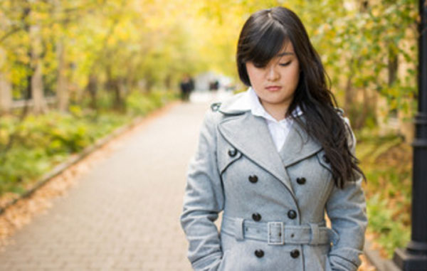 Девушка с опущенными глазами идет по улице