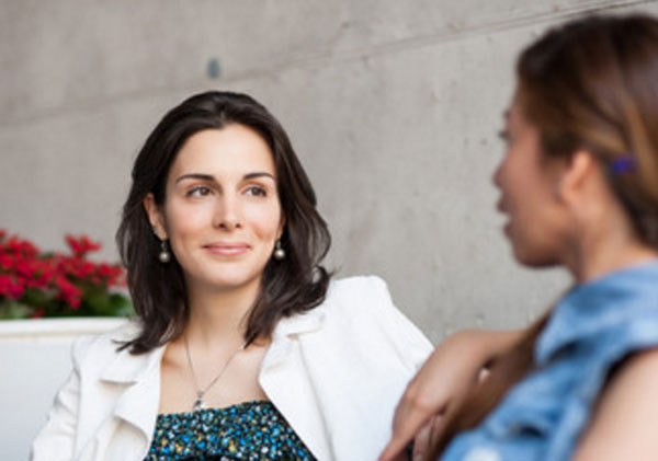 Женщины общаются. Одна мило улыбается