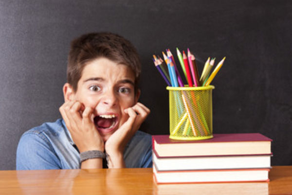 На лице мальчика ужас. Рядом стол со школьными принадлежностями