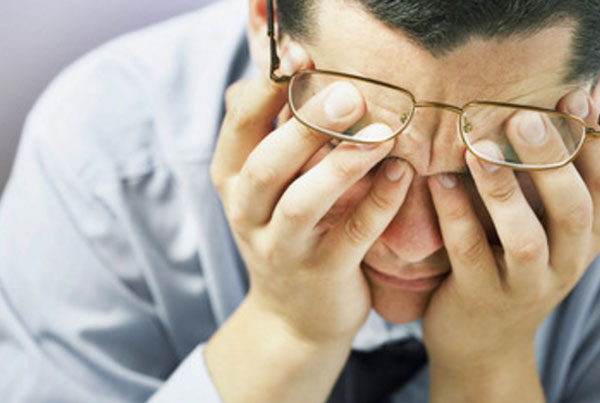 Мужчина приложил руки к глазам, очки приподнялись