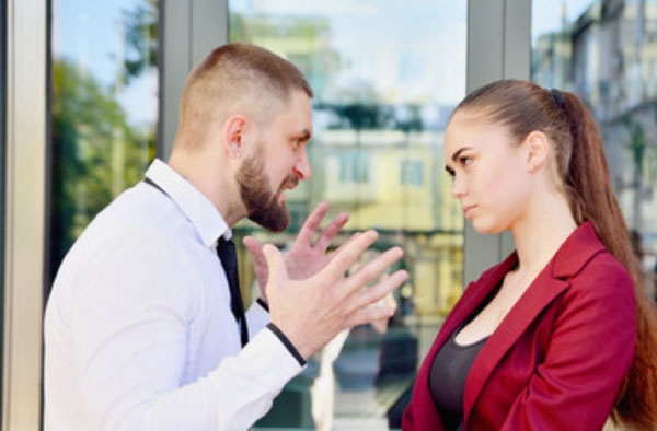 Злой мужчина что-то высказывает девушке
