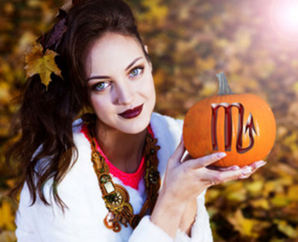 Девушка в осеннем парке. Держит в руках тыкву, на которой нарисован знак Скорпиона