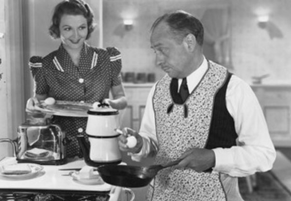 Мужчина в фартуке готовит еду