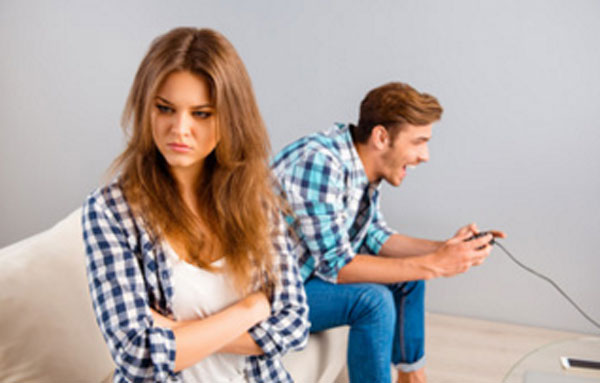 Парень играет на приставке, девушка грустит