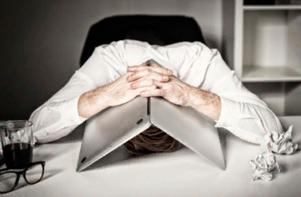 Мужчина положил голову на стол и накрыл лицо ноутом