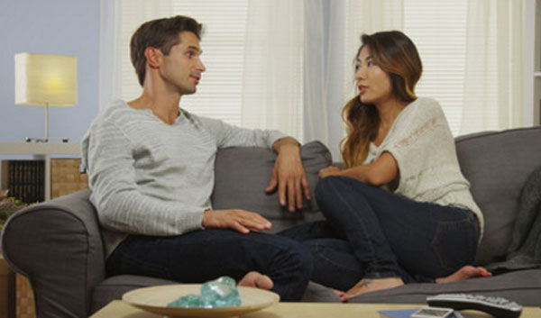 Жена с мужем разговаривают, сидя на диване