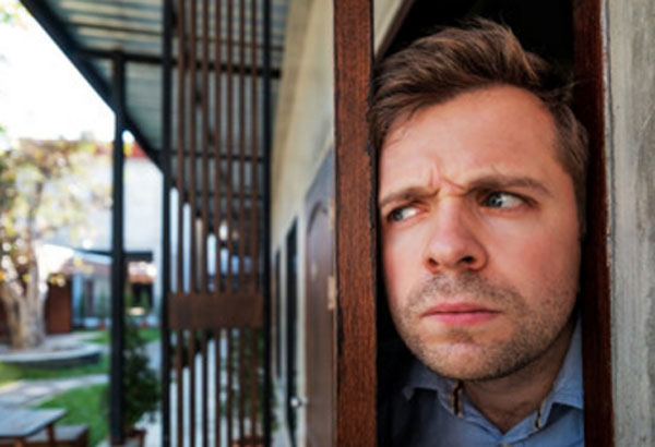 Мужчина приоткрыл дверь, выглядывает. Он напряжен