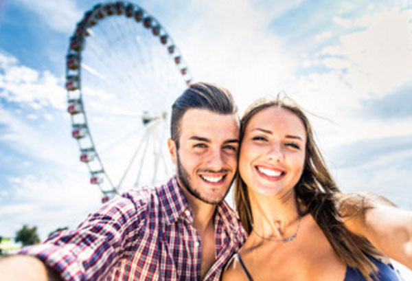Счастливая пара на фоне чертового колеса