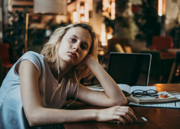 Женщина расстроена. Сидит возле выключенного ноутбука. На столе лежат ее очки