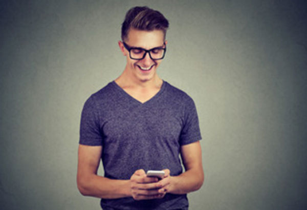 Парень печатает сообщение на телефоне