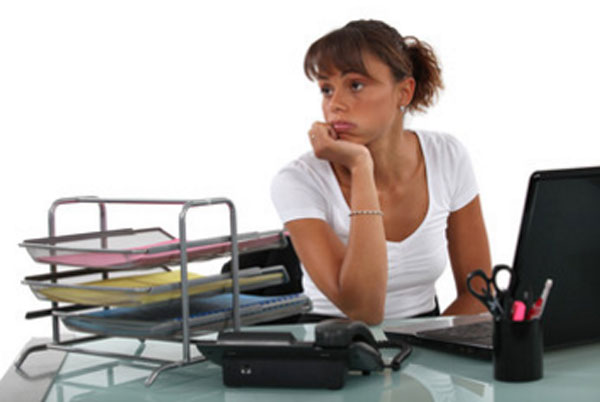 Печальная, расстроенная женщина сидит на рабочем месте и не знает, что делать