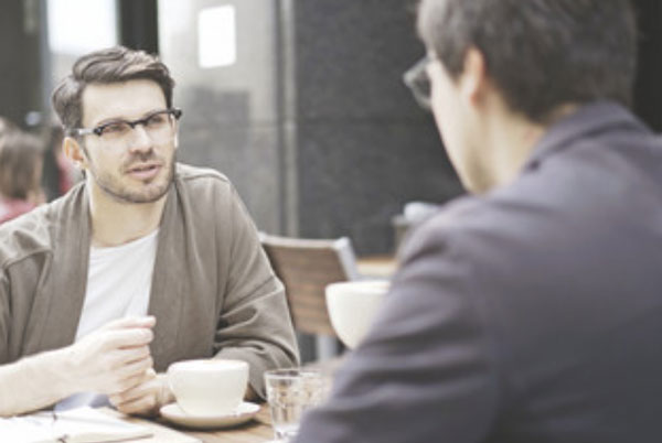 Один мужчина говорит что-то другому