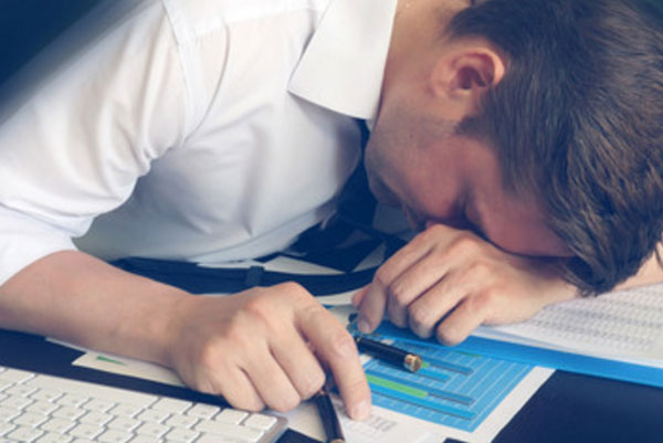 Уставший мужчина положил голову на стол