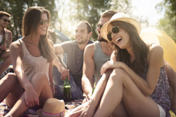 Компания молодых девушек и мужчин на пикнике