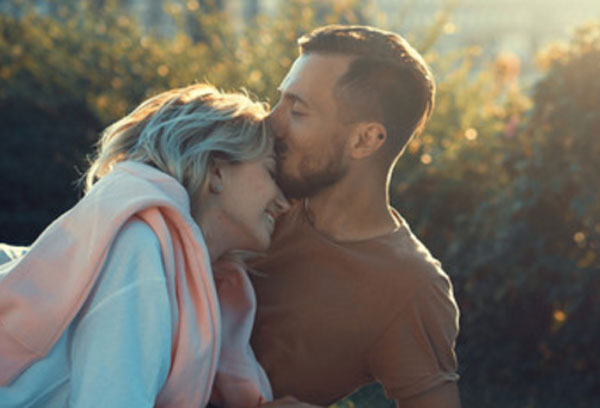 Счастливая пара. Мужчина целует девушку в лоб