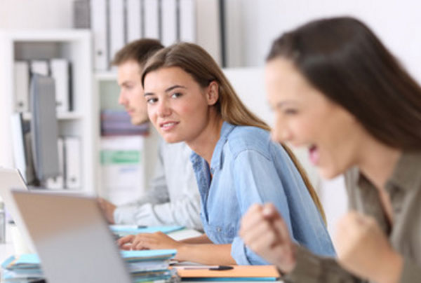 Девушка радутся увиденному на экране ноутбука