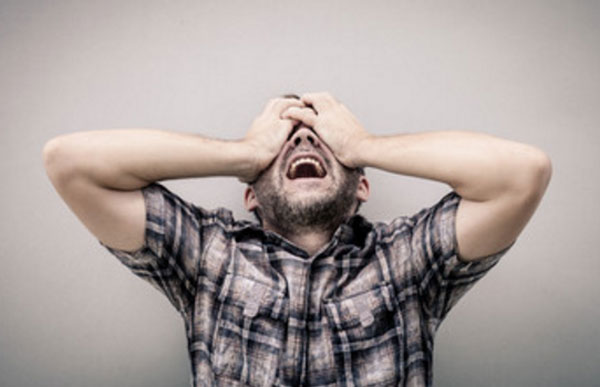 Мужчина то ли плачет, то ли кричит. Закрывает глаза руками