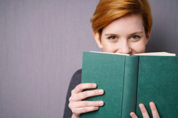 Улыбающаяся девушка с книжкой в руках