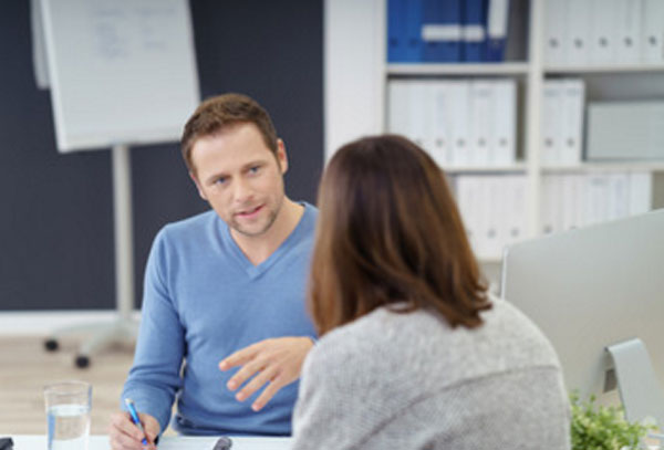 Мужчина осторожно общается с женщиной, которая сидит спиной к камере