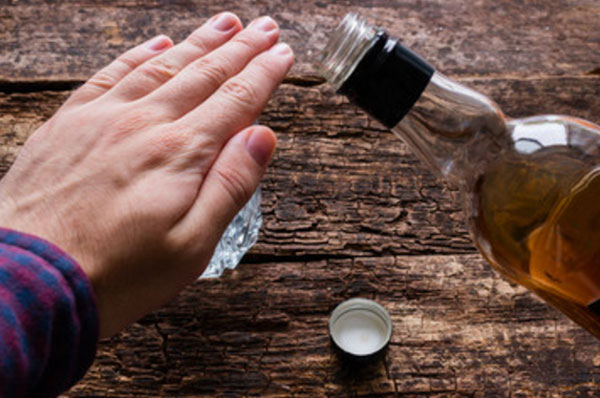 Мужчина рукой закрывает стопку, чтоб ему не наливали